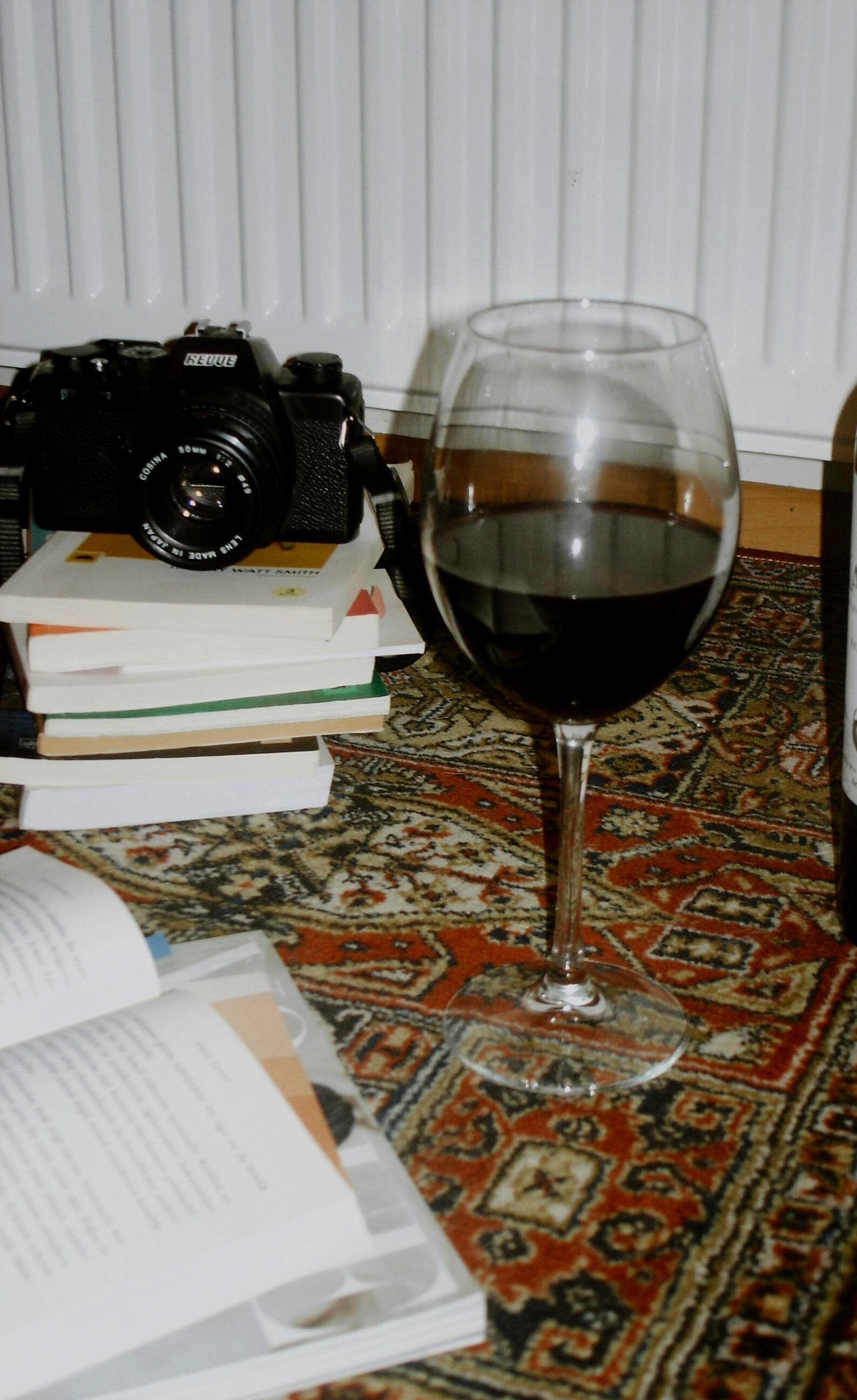 Lifestyle flat lay with wine, camera and books