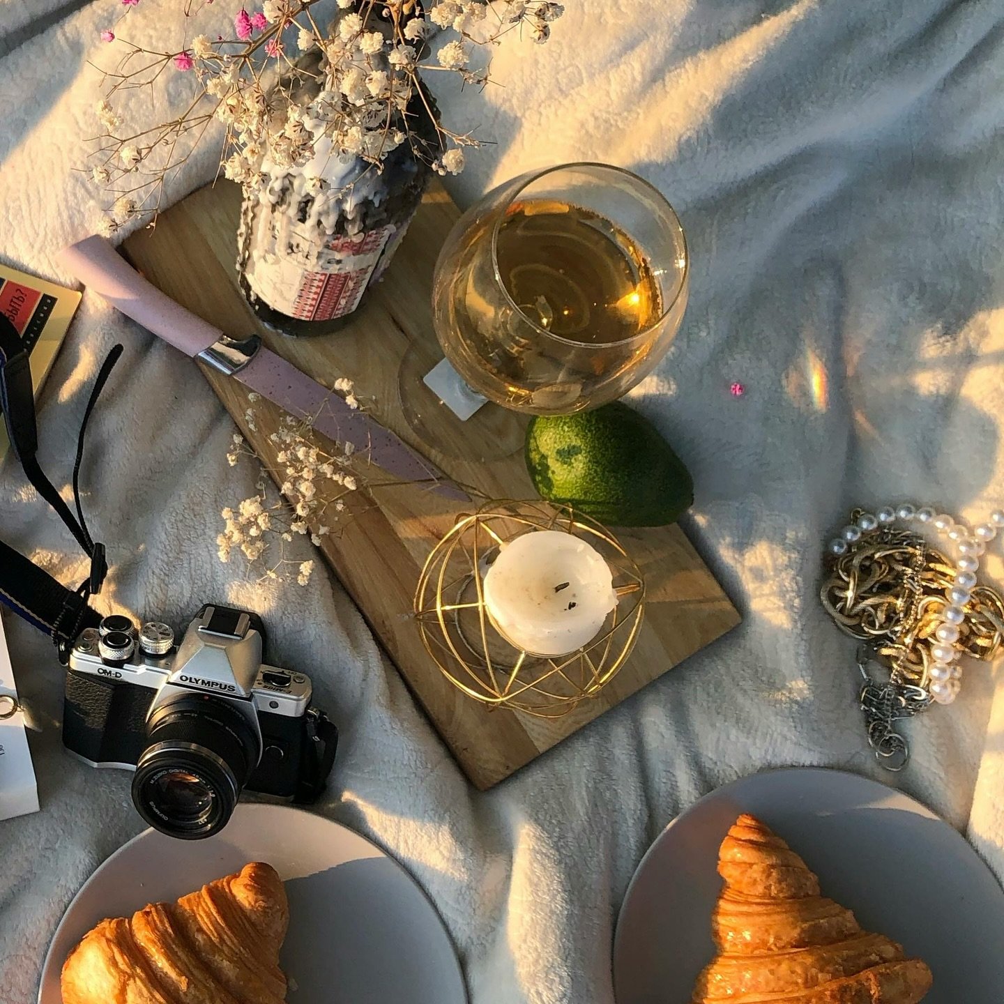 Flat lay with croissants, wine, camera and flowers